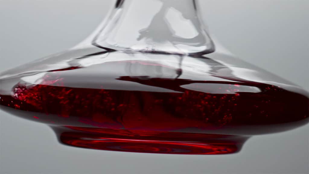 Closeup of decanter swirling wine in slow motion