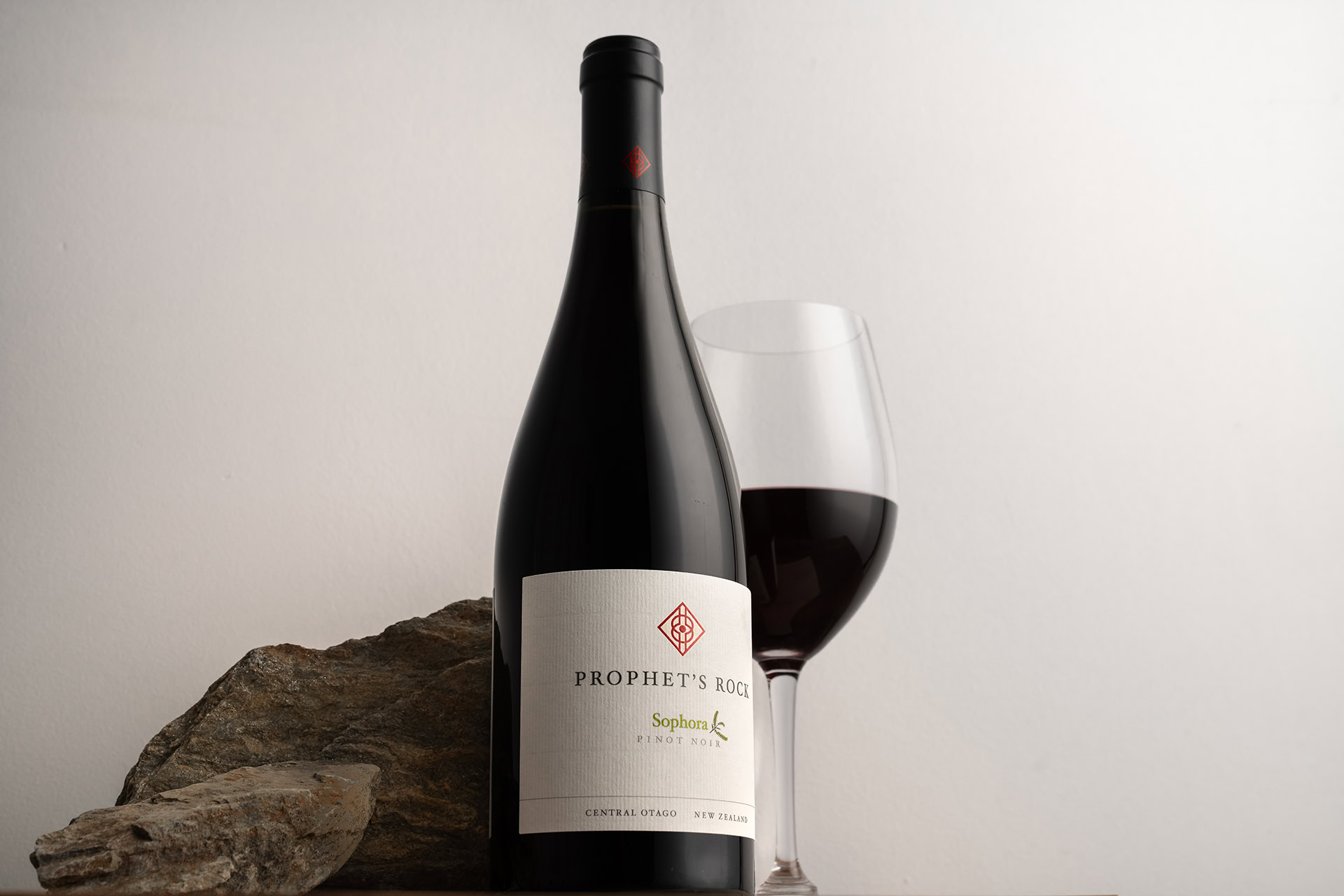 Prophet's Rock Sophora Pinot Noir with a glass of red wine and a schist rock